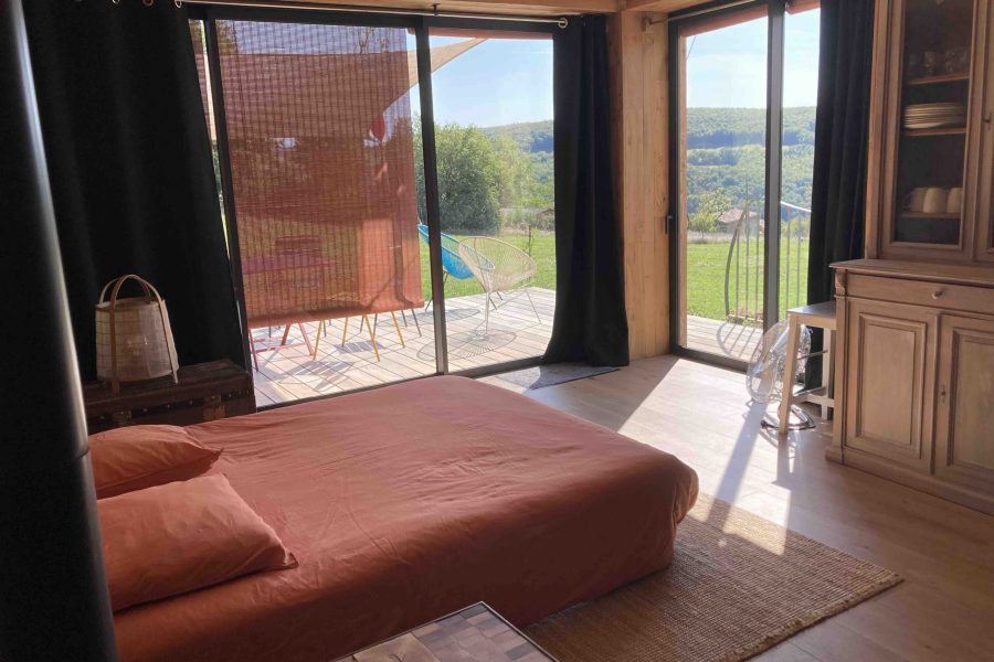 salon avec canapé-lit ouvert sur la nature environnante